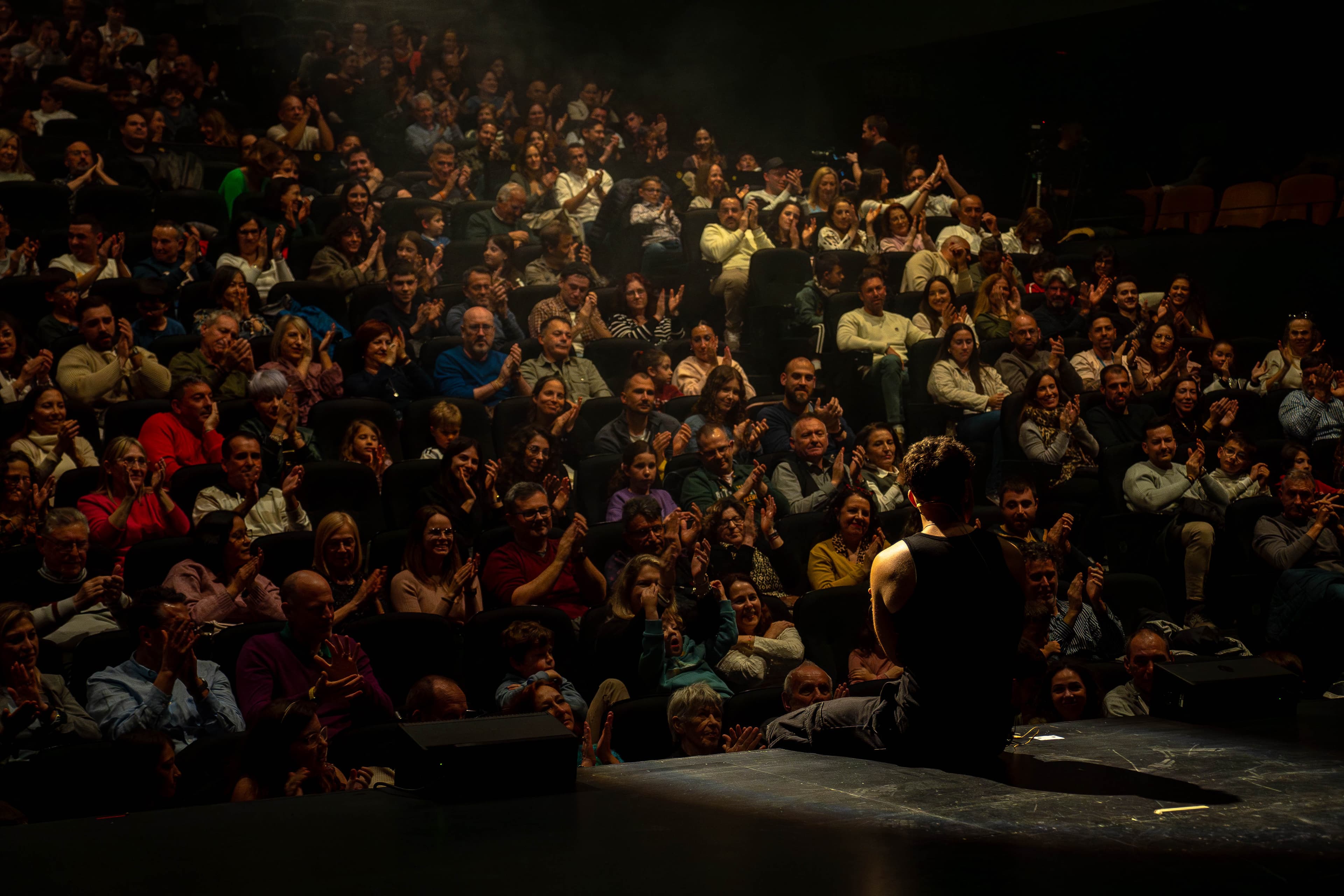 Pando junto a las primeras filas de público en un teatro
